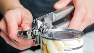 A person using a tin opener