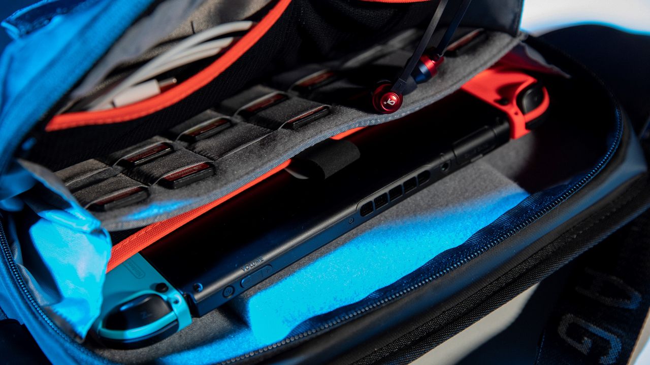CS03 bag opened with Nintendo Switch and game cards in pockets.