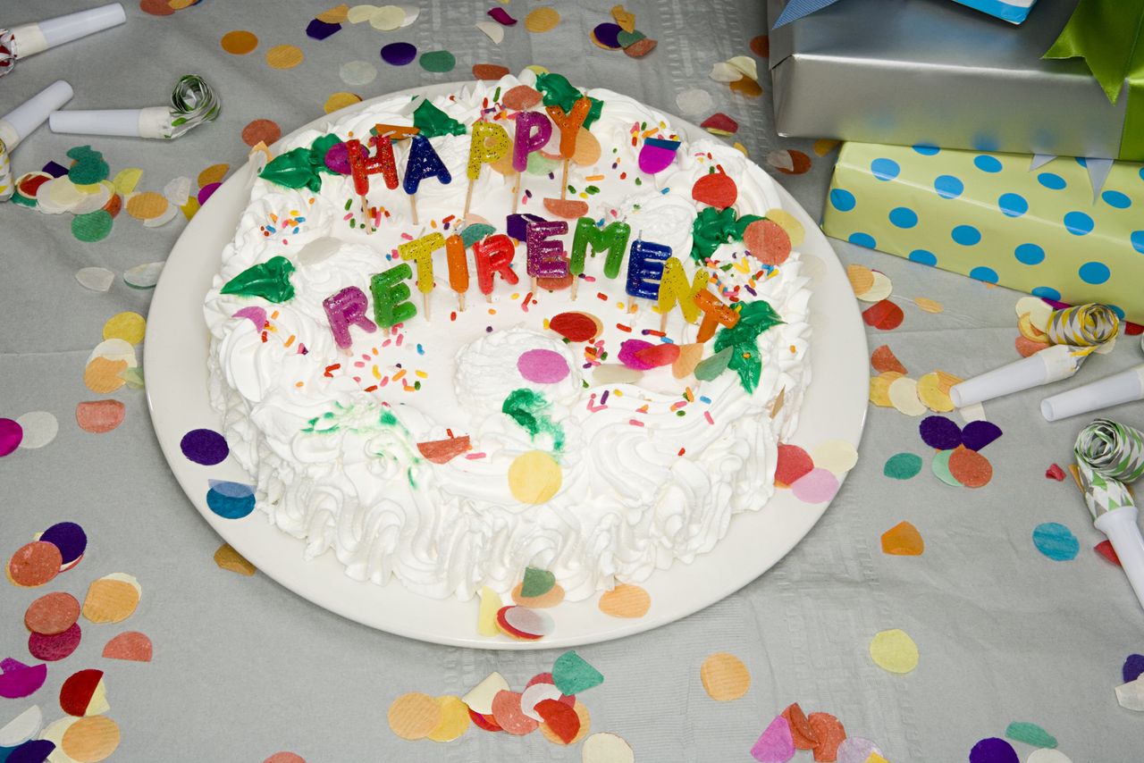 A half-eaten cake at a retirement party with &quot;happy retirement&quot; written in icing.