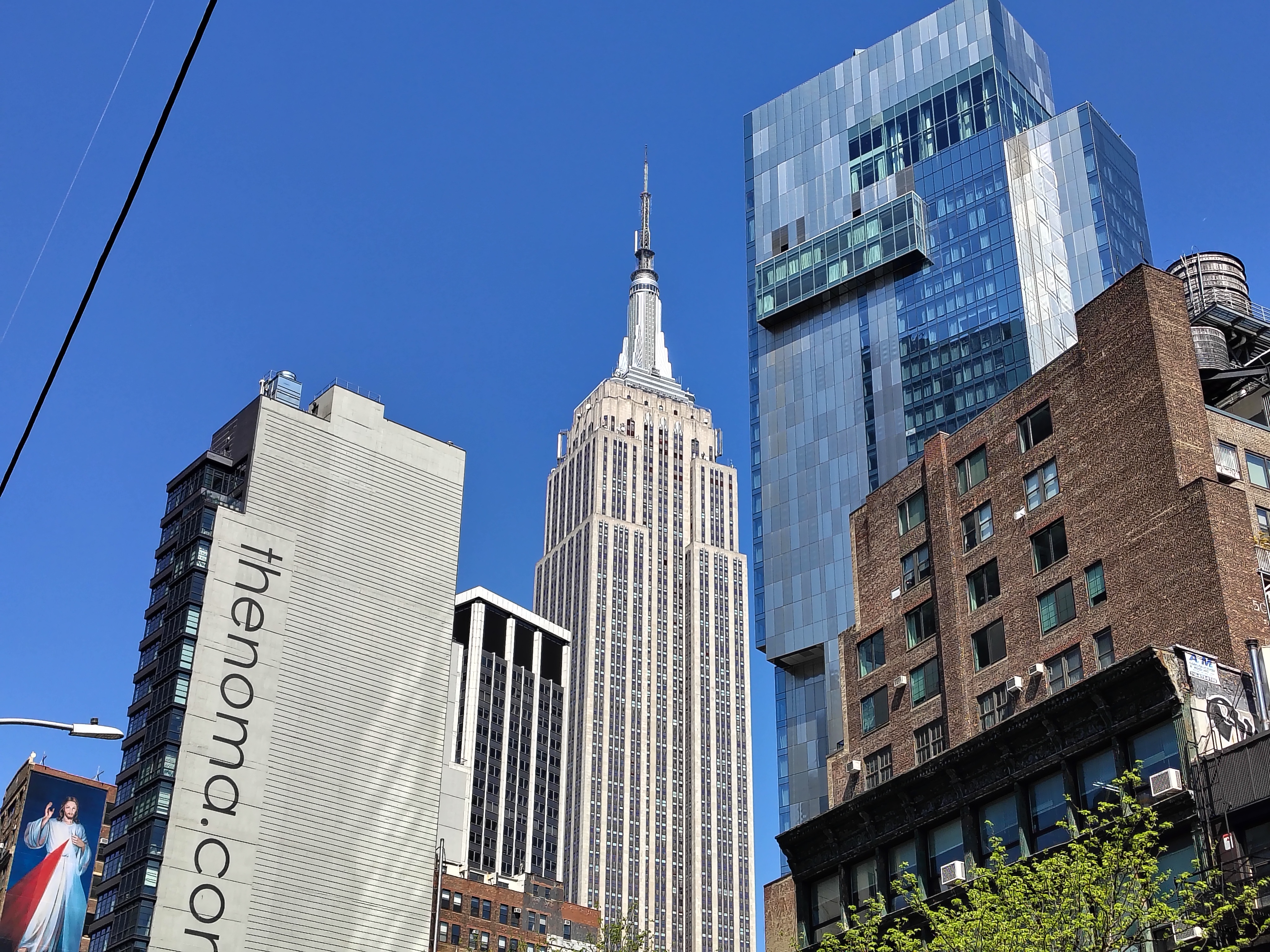 The Empire State Building next to other tlal buildings