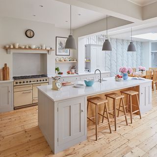 kitchen with white wall wooden flooring white counter and wooden table