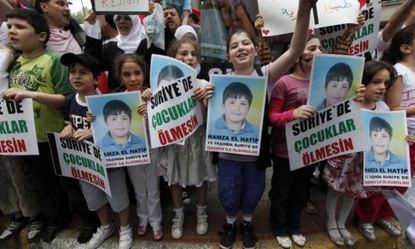 Syrian children carry images of a 13-year-old boy whose death by torture invigorated a protest that may be morphing into an armed rebellion.