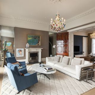 drawing room with chandelier and sofa with cushion and cosy carpet
