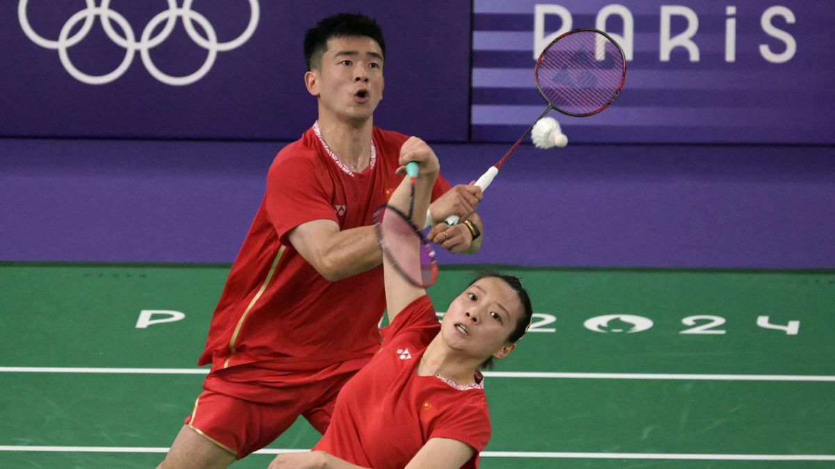 China&#039;s Huang Ya Qiong (R) hits a shot next to Zheng Siwei in their mixed doubles badminton, dressed in red shorts and t-shirts, at the 2024 Paris Olympic Games.