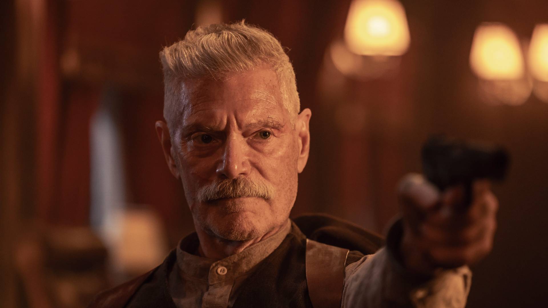 Stephen Lang as Igor Draganov, holding a gun, in Sisu: Road to Revenge
