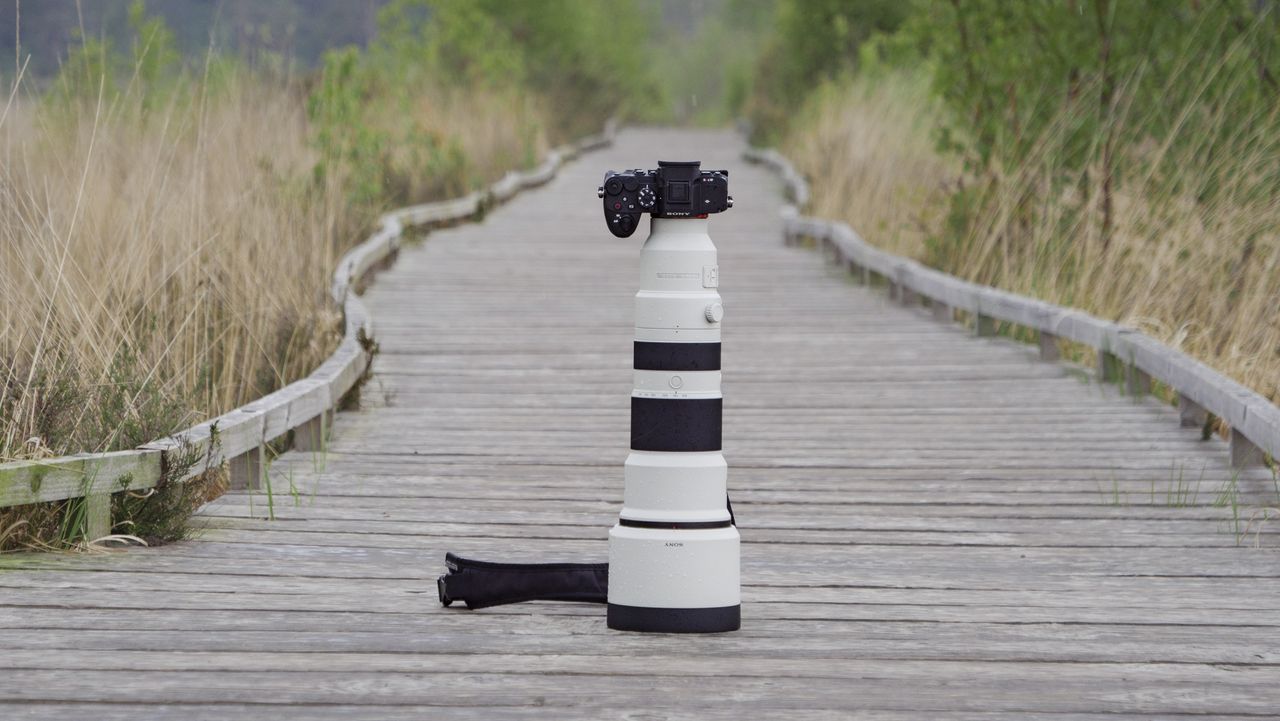The Sony A7R VI with the FE 400-800mm F6.3-8 G OSS supertelephoto zoom lens attached, stood on a boardwalk in a nature reserve