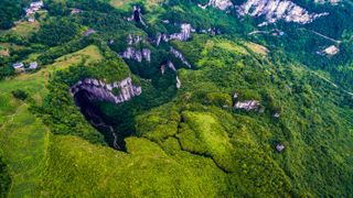 This image shows a typical karst sinkhole called a tiankeng in Chongqing, China.