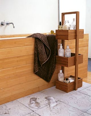 Bathroom with storage caddy alongside bath with wood panel