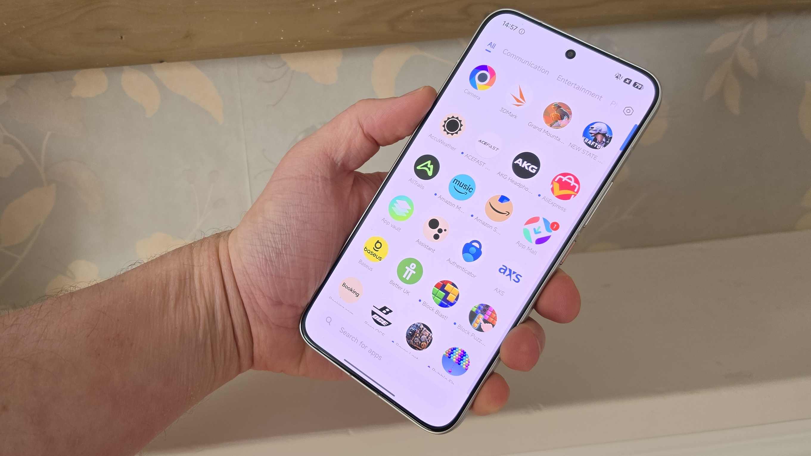 The Poco X8 Pro Max in a man's hand, while it's in the app drawer.