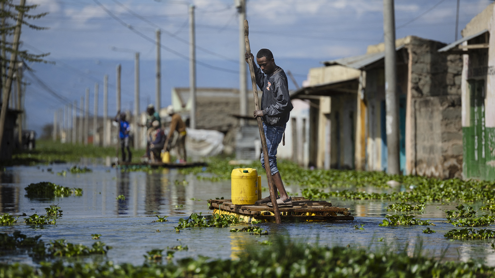 A resident uses a makeshift raft to navigate the flooded streets of Naivasha, Kenya