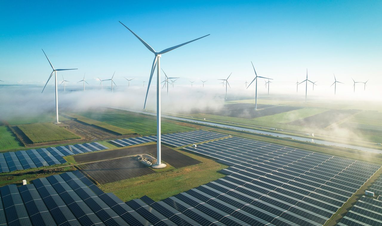 Solar energy and wind turbines in fog, seen from the air