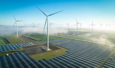 Solar energy and wind turbines in fog, seen from the air