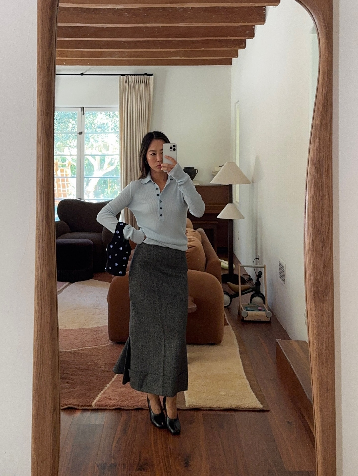 Aimee Song wears a blue polo sweater and heather grey knit skirt.