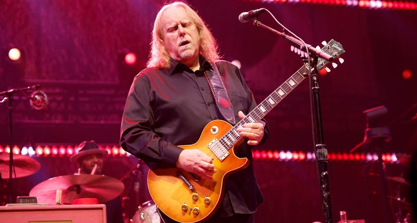 Warren Haynes takes a solo live onstage with his Gibson Les Paul Standard. He wears a black shirt.