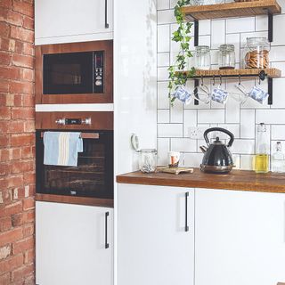 Kitchen with white cupboards and a built-in oven
