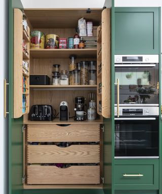 forest gren shaker style kitchen with wooden pantry style shelving