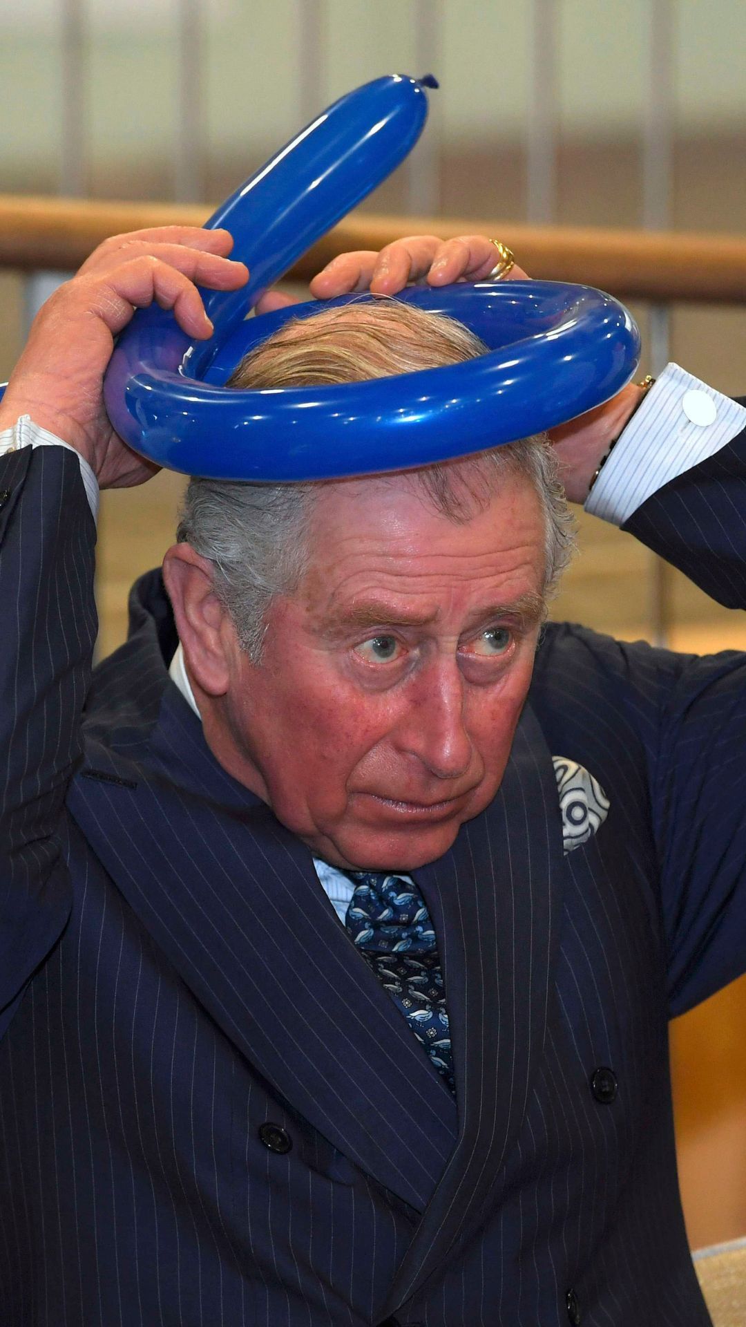 King Charles wearing a balloon hat.