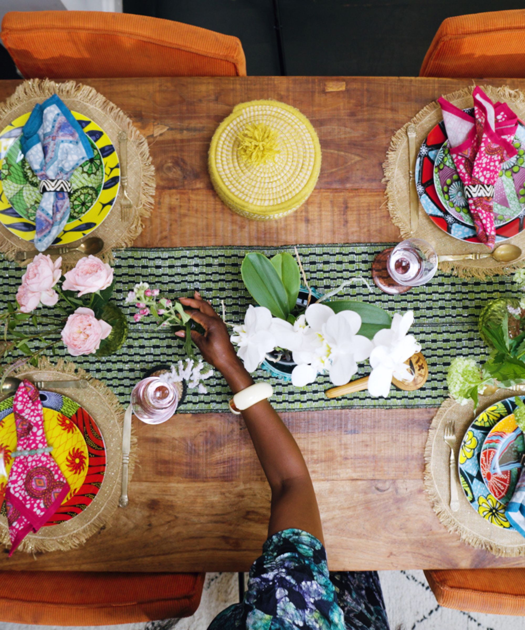 Eva Sonaike laying her table with African plates, flowers and colorful accessories