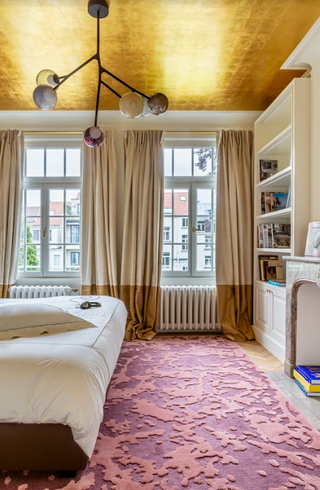 A bedroom with a gold painted ceiling