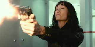 Maggie Q angrily firing a gun in The Protégé.