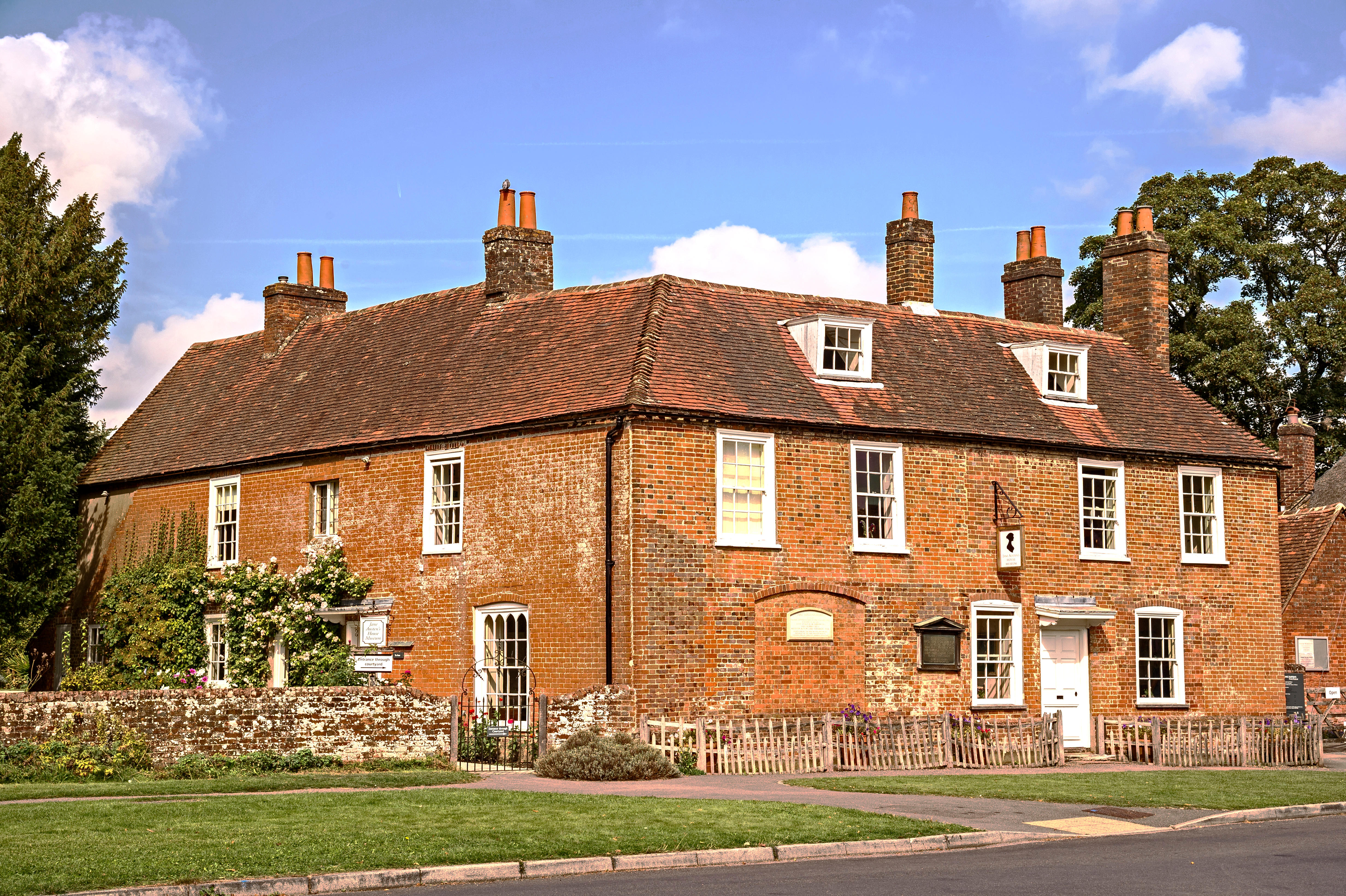 Red brick l-shaped house with white sash windows