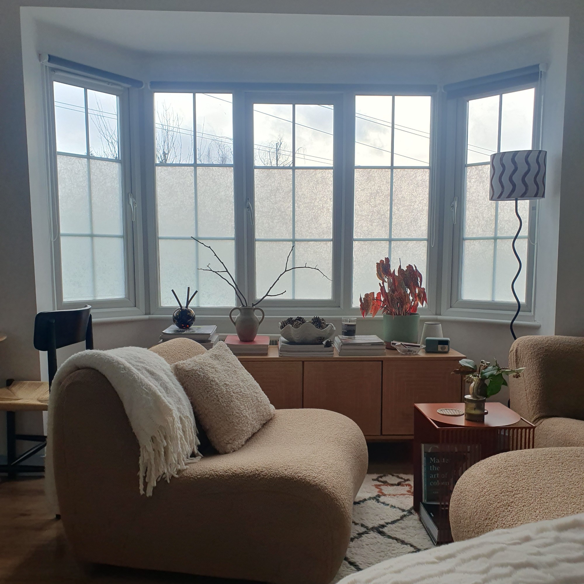 The living area in my studio flat with my modular King Living 1977 sofa and Habitat sideboard placed in my bay window