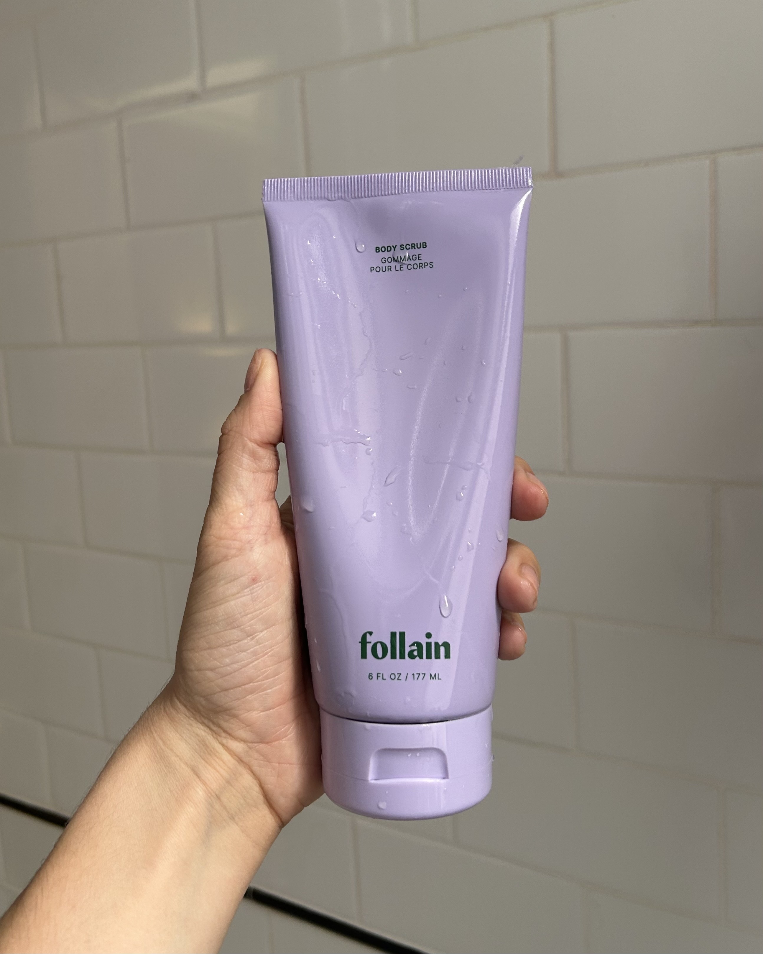 An image of Alyssa Brascia holding the Follain Body Scrub.