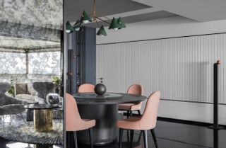 A dining room with black flooring and pink chairs