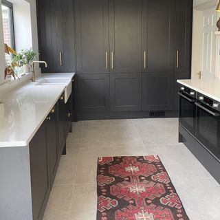 Navy kitchen with runner rug in middle.