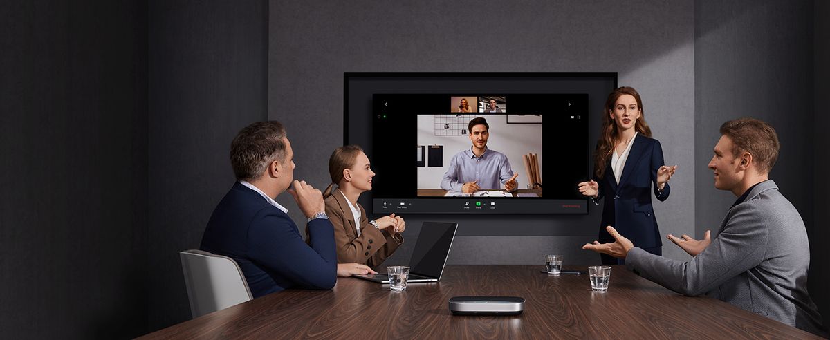 People in a board room use an AnkerWerk speakerphone for a hybrid meeting.