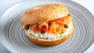 Smoked salmon on a bagel with cream cheese and capers, one of the best foods to eat after a workout