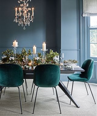 Christmas table centerpiece with blue walls and foliage
