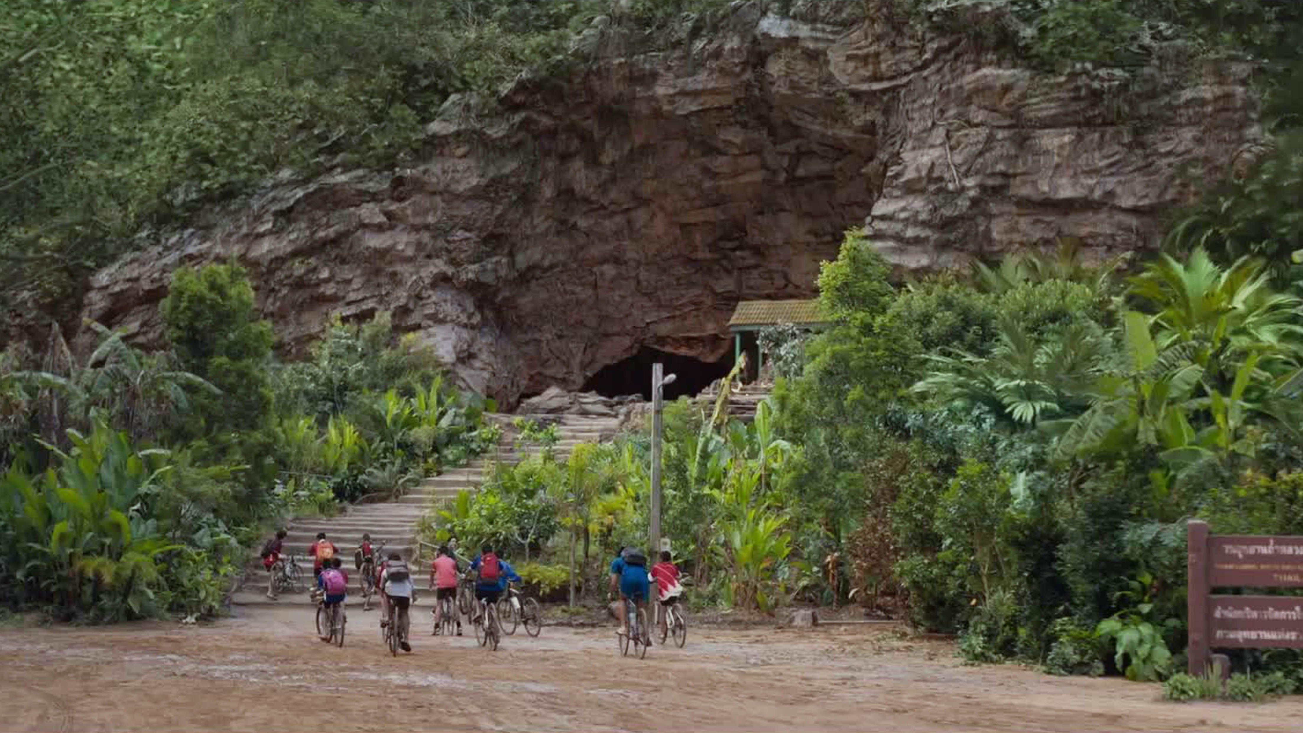A still from &quot;Thirteen Lives&quot; showing the boys football team cycling towards the cave