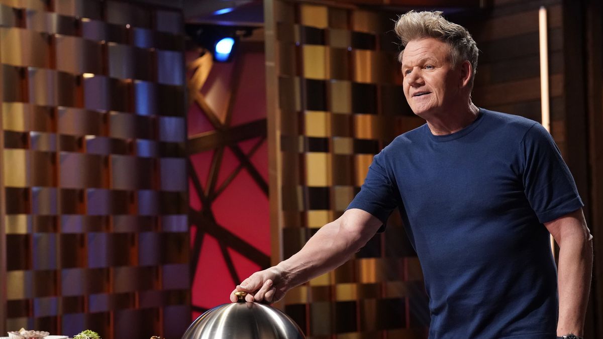 Gordon Ramsay about to lift the cover off of a dish in Masterchef season 14