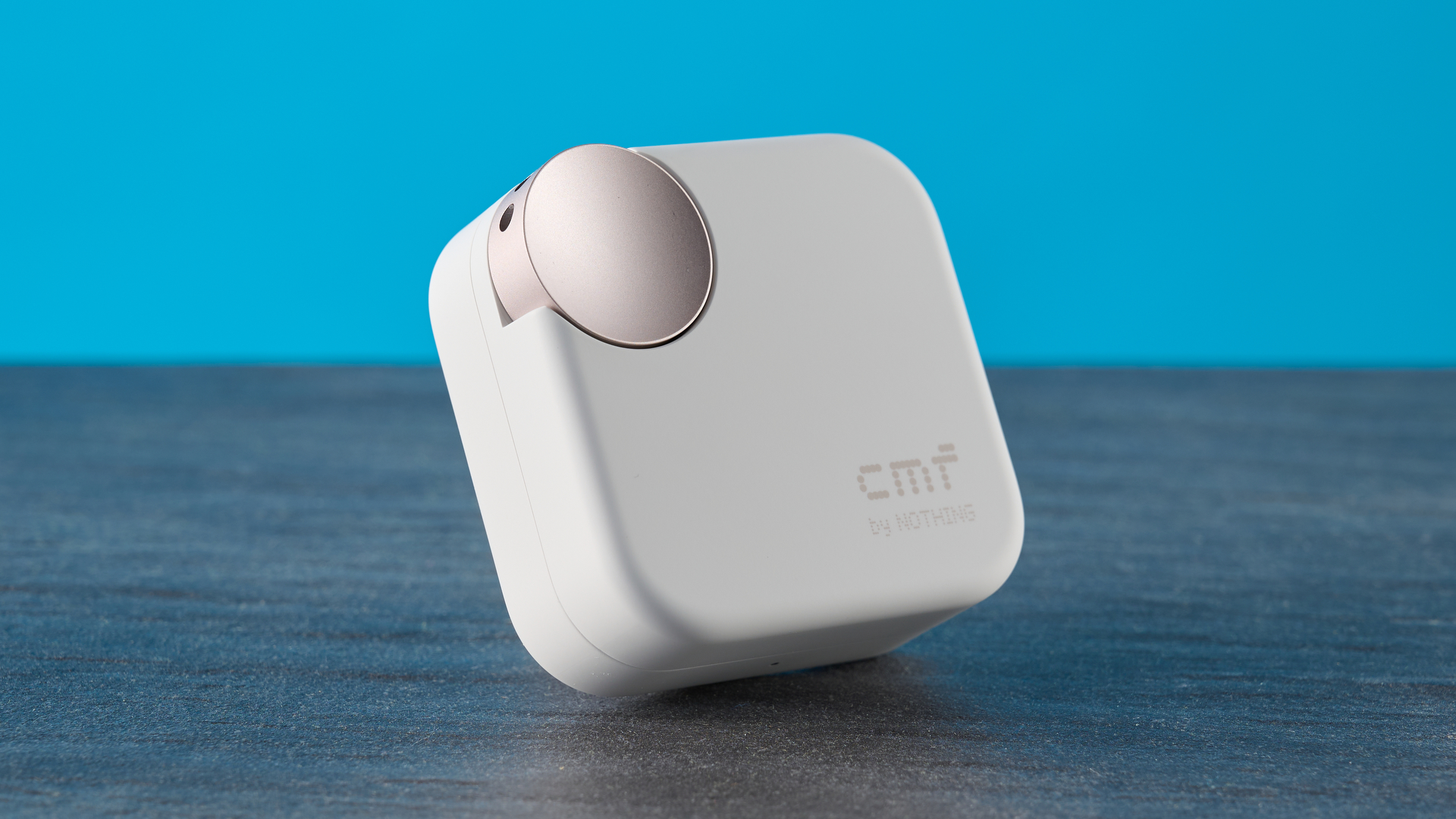 CMF Buds 2 Plus in light gray photographed in front of a blue background