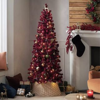 Habitat 6ft Snowy Christmas Tree in Burgundy in the corner of a living room with a fireplace