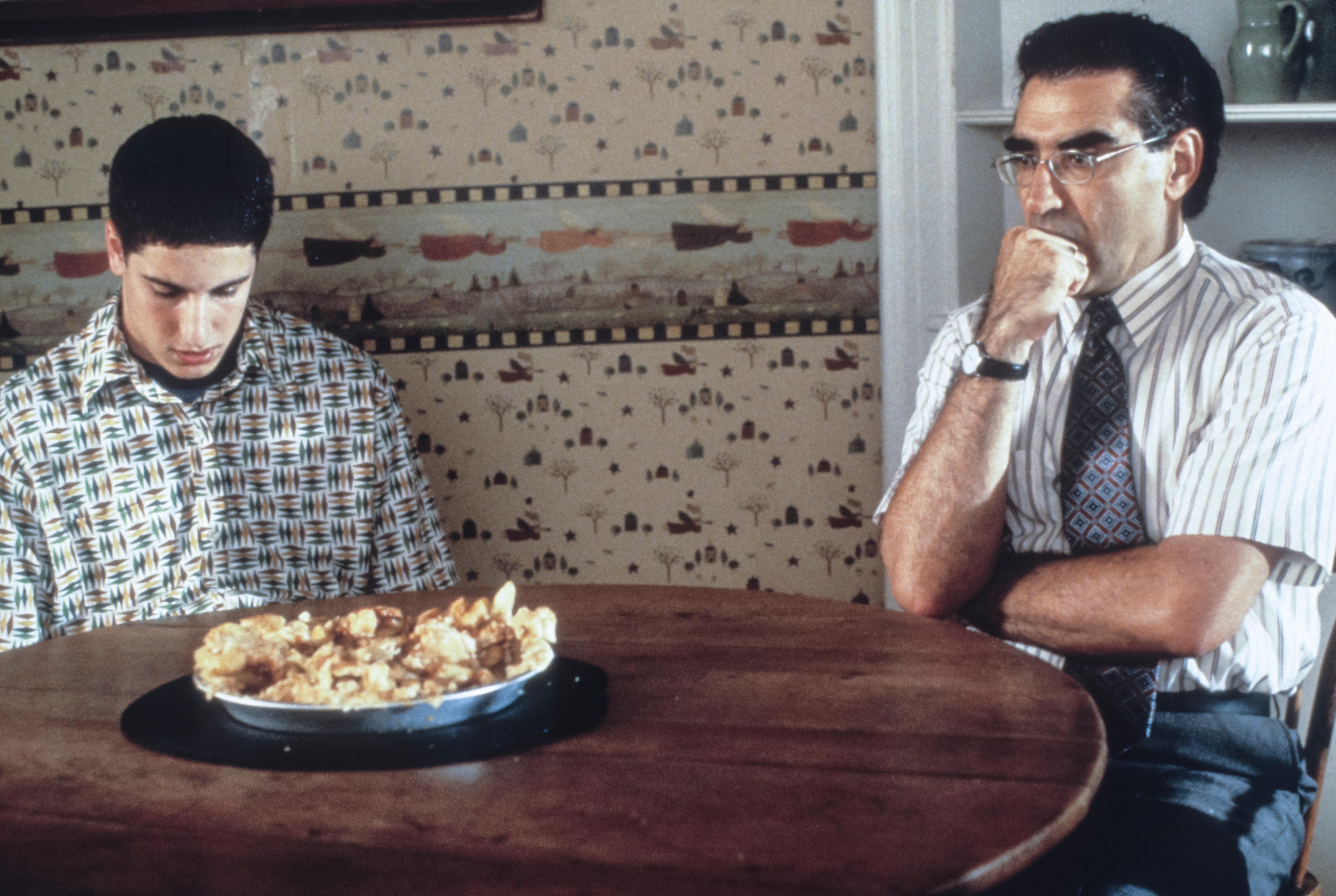 Jason Biggs and Eugene Levy star in 'American Pie' sitting at a table with a pie on it