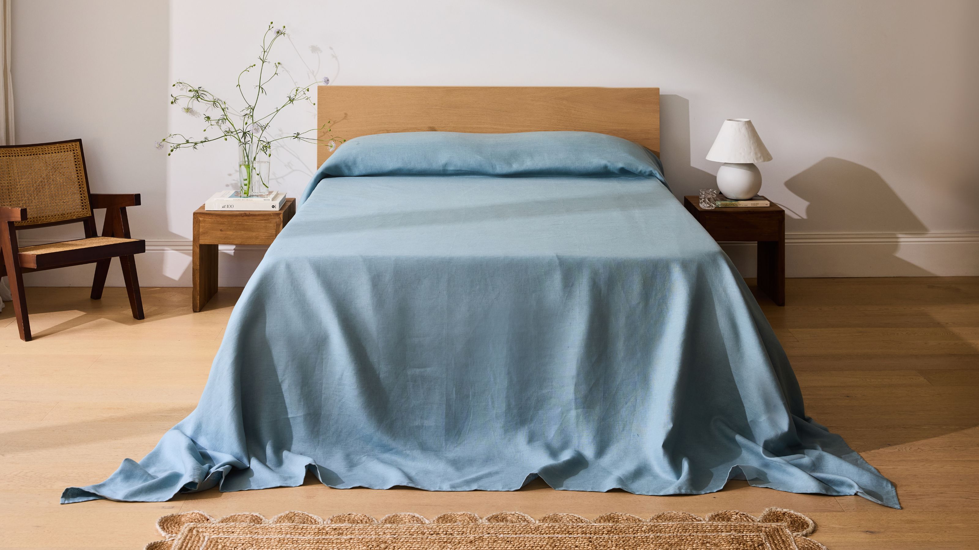Bed Threads Heavy Linen Bed Cover in blue in a bedroom with timber floor, timber headboard, timber chair