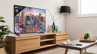 TCL 5-Series TV (2018) on a TV stand in a living room and displaying a city scape