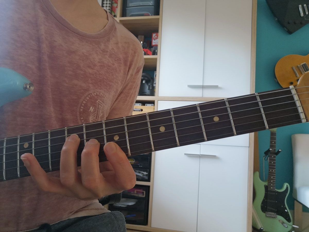 A person showing how to play a B using &lsquo;F shape&rsquo;