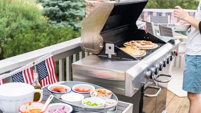 Preparing individual grilled pizzas on an outdoor gas grill