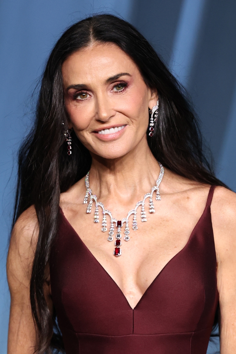 Demi Moore is pictured with long, dark brown hair and wearing a burgundy dress at the 5th Annual Academy Museum Gala at the Academy Museum of Motion Pictures on October 18, 2025 in Los Angeles, California.