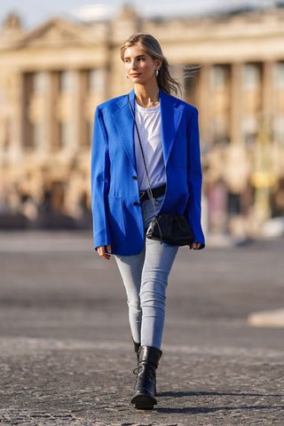 A woman wearing a blue blazer and skinny jeans