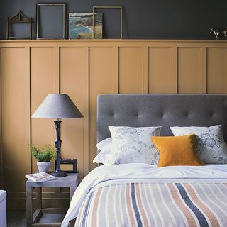 bedroom with table lamp and grey headboard