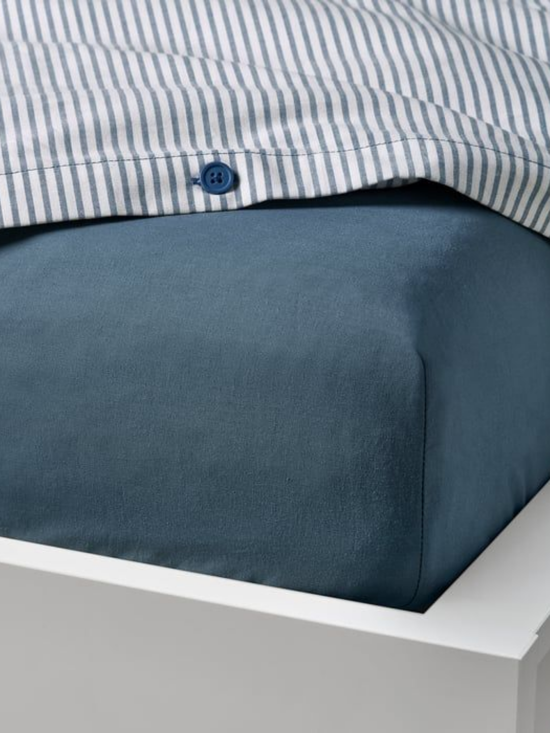 A close-up of a fitted blue sheet from IKEA
