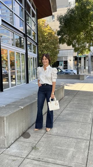 A former Nordstrom buyer wearing a white blouse with dark wash jeans.