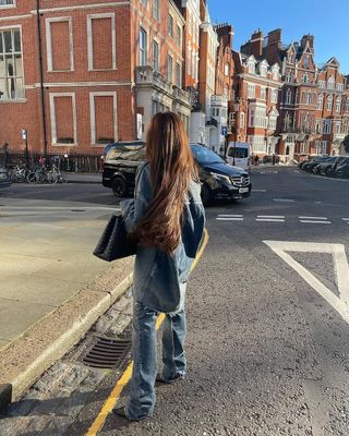 woman wearing oversized denim shirt and baggy jeans with stiletto heels