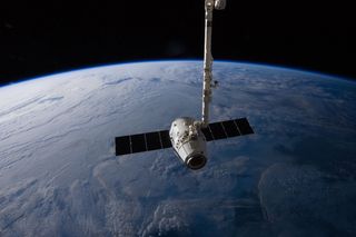 A SpaceX Dragon commercial cargo craft is seen in the the grips of the Canadarm2 before being released May 31, 2012. The space station's robotic arm is used to capture and release SpaceX Dragon cargo ships during their resupply missions.