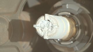 a chalk-like rock sample on the end of a threaded metal tube