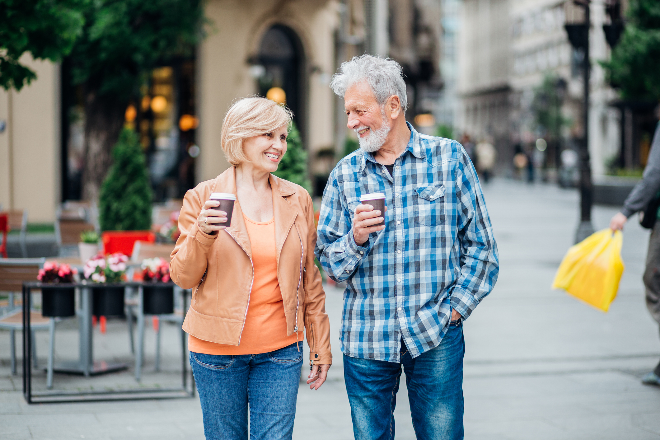 Happy mature heterosexual couple having a coffee during their city walk.